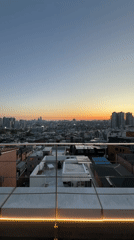 Women photograph sunset from Seoul rooftop