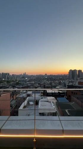 Women photograph sunset from Seoul rooftop