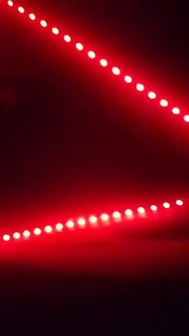 The video shows a strip of LED lights changing colors. The colors cycle through blue, green, red, and a mix of purple and blue. The LED strip is arranged in a diagonal line across a dark background.