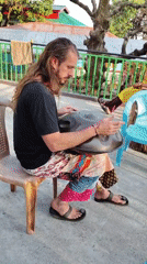 Street musician plays handpan drum in Bhagsu, India
