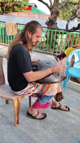 Street musician plays handpan drum in Bhagsu, India