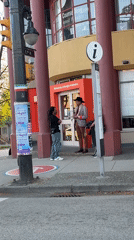 Three people gather outside Vancouver building with welcome message