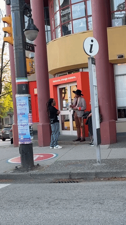 Three people gather outside Vancouver building with welcome message