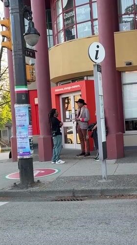 Three people gather outside Vancouver building with welcome message