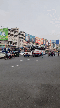 Bus travels through overcast Dhaka street