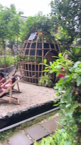 Women sunbathe near firepit in tropical Thai outdoor space