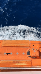 Orange lifeboat observed moving through choppy Mediterranean waters