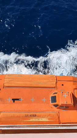 Orange lifeboat observed moving through choppy Mediterranean waters