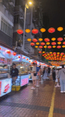 Hong Kong street food market bustles under colorful lanterns
