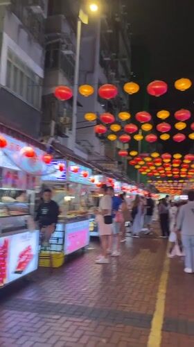 Hong Kong street food market bustles under colorful lanterns