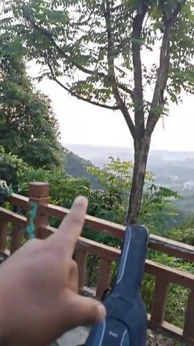 Person points to guitar case near fence in Shapingba District