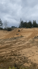 Dirt bikers navigate sandy dune in rural Belarus