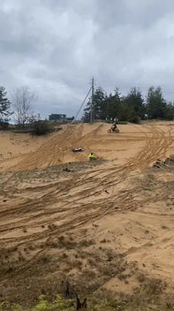 Dirt bikers navigate sandy dune in rural Belarus