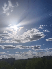 Woman photographs herself at window during sunny afternoon
