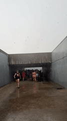Beachgoers shelter from summer rain at New York shoreline