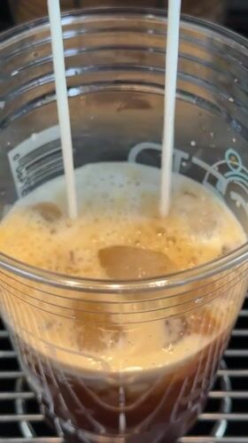 Milk dispensed into iced coffee drink in Vancouver
