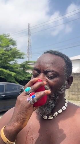 Eating red fruit outdoors in Ado, Nigeria
