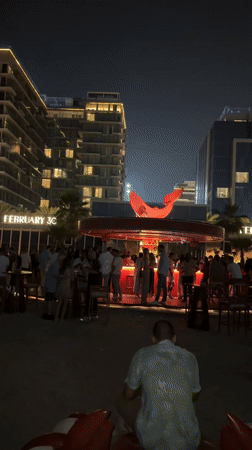 Nighttime crowd fills circular FEBRUARY 30 bar in Dubai