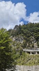 Mountain road traffic through forested cliffs near Ferlach, Austria