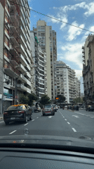 Vehicle travels through Buenos Aires residential street corridor