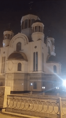 Evening moments captured in Yekaterinburg: illuminated church, relaxing dog