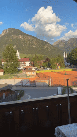 Tourist documents scenic Oberstdorf views from balcony overlook