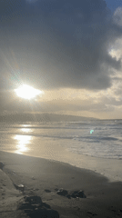 Dramatic sunset breaks through clouds over Ribeira Grande beach