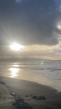 Dramatic sunset breaks through clouds over Ribeira Grande beach