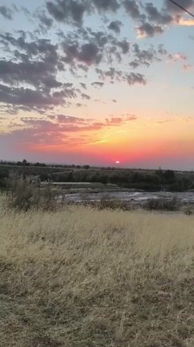 Golden sunset over Kyrgyzstan's open steppe and river plain