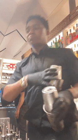 Bartender prepares cocktails during evening shift in Barcelona