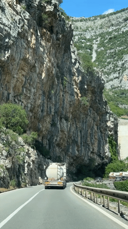 Tank truck travels highway near cliff face in Montenegro