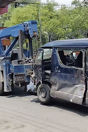 Damaged blue van towed through Dhaka streets