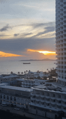 Sunset documented over Pattaya coastline with ships and cityscape