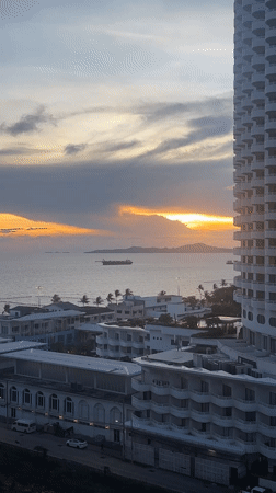 Sunset documented over Pattaya coastline with ships and cityscape