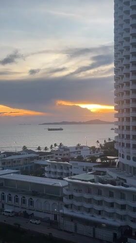 Sunset documented over Pattaya coastline with ships and cityscape