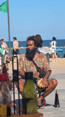 Street musicians perform on sunny Barcelona beach promenade