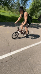 Cyclist performs tricks in Krasnoyarsk park near river bridge