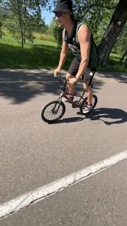 Cyclist performs tricks in Krasnoyarsk park near river bridge