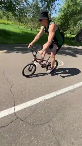 Cyclist performs tricks in Krasnoyarsk park near river bridge