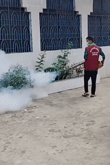 Fumigation worker sprays building in Dhaka residential area