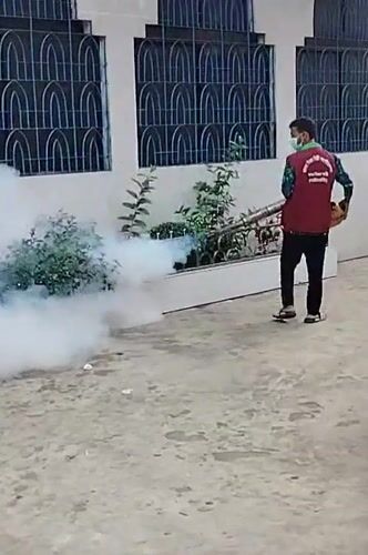 Fumigation worker sprays building in Dhaka residential area