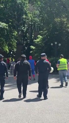 Security escorts costumed individual in Yerevan gathering