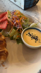 Diner documents croissant meal on blue-patterned plate