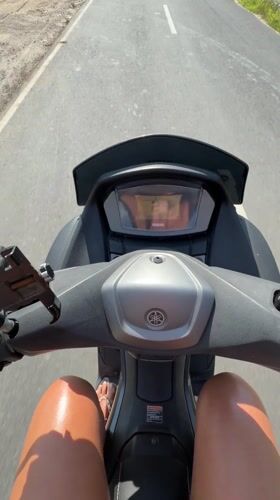 Woman rides Yamaha scooter through Kuta Selatan Indonesia