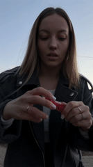 Woman applies lip gloss outdoors in Klin, Russia