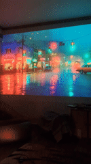 Rainy city street projection displayed in dimly lit room