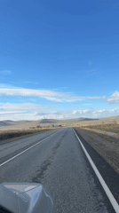 Vehicle travels rural Russian road under clear skies