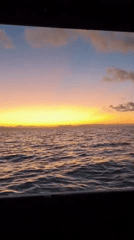 Ocean sunset viewed through window in Indonesia
