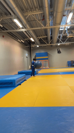Judo kids spar and drill with foam weapons in a gym