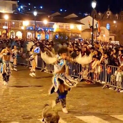 Traditional parade with costumed dancers in Cuzco's cobblestone streets